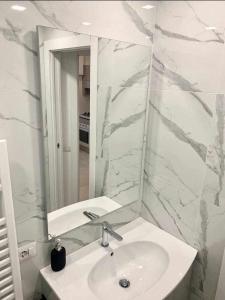 ein weißes Badezimmer mit einem Waschbecken und einem Spiegel in der Unterkunft Le Suite Abitare Roma in Rom