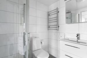 La salle de bains blanche est pourvue de toilettes et d'un lavabo. dans l'établissement Åreskutan Huså lägenhet 5, à Huså