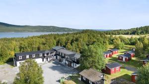 - une vue aérienne sur une maison avec des arbres et un lac dans l'établissement Åreskutan Huså lägenhet 5, à Huså