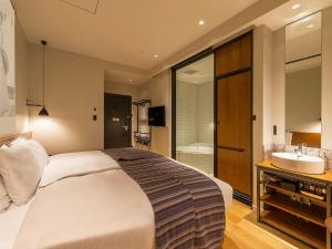 Postel nebo postele na pokoji v ubytování Ebisuholic Hotel