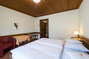 - une chambre avec deux lits, une chaise et une table dans l'établissement Gästehaus Sägemühle, à Russbach am Pass Gschütt