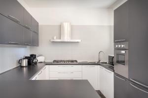 cocina con armarios blancos y fogones en Villa Loncrino, First Floor Apartment, en Torri del Benaco