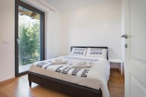 Bett in einem Zimmer mit einem großen Fenster in der Unterkunft Villa Loncrino, First Floor Apartment in Torri del Benaco