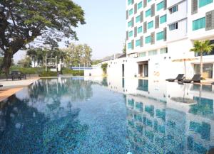 a swimming pool in front of a building at Sann Hotel in Chiang Rai