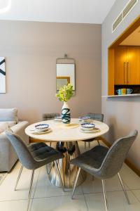 comedor con mesa y sillas en Vacay Lettings - Iris blue spectacular Marina view Apartment, en Dubái