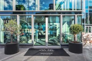 two potted trees in front of a building at INNSiDE by Meli&aacute; Amsterdam in Amsterdam
