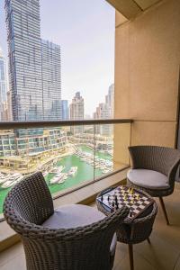 un balcón con 2 sillas y un tablero de ajedrez en Vacay Lettings - Iris blue spectacular Marina view Apartment, en Dubái