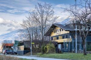 ein Haus an der Seite einer Straße mit einem Berg in der Unterkunft The Art and Sporthotel in Innsbruck