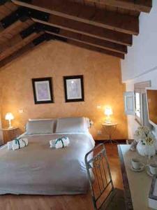 a bedroom with a white bed with two towels on it at B&B Casa del Teatro in Mantova