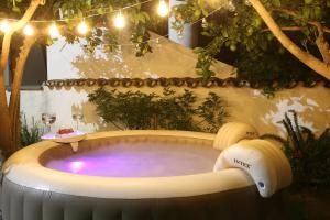 una bañera de hidromasaje en un jardín con copas de vino en A Janela Do Castelo, en Monsaraz
