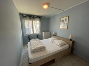 Schlafzimmer mit einem Bett und einem Fenster in der Unterkunft Les forestiers in Mimizan