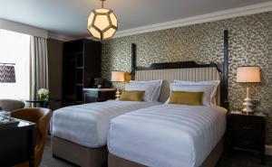 duas camas num quarto de hotel com duas lâmpadas em The Academy - Small Luxury Hotels of the World em Londres