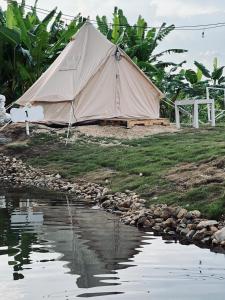 ein Zelt neben einem Wasserkörper in der Unterkunft 3199 Cafe' Latya 