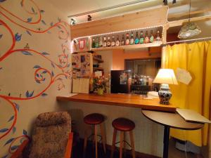bar z dwoma stołkami i ladą w pokoju w obiekcie Guest House mii w Osace