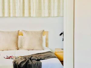 1 dormitorio con 1 cama con sábanas blancas y espejo en Canaryislandshost I Marquesa en Famara