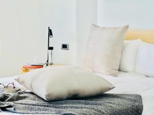 a white bed with white pillows and a lamp at Canaryislandshost I Marquesa in Famara