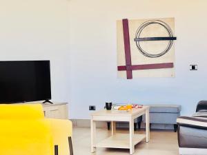 sala de estar con TV y mesa en Canaryislandshost I Marquesa en Famara