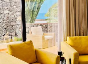 a living room with a yellow couch and a large window at Canaryislandshost I Marquesa in Famara
