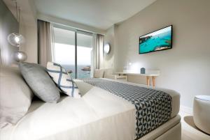 a hotel room with a bed and a window at Palladium Hotel Menorca in Arenal d'en Castell