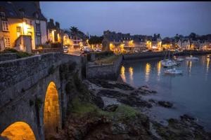 un pont sur une rivière la nuit avec des bateaux dans l'eau dans l'établissement Les gîtes de Madline, Le petit Solidor, à Saint-Malo