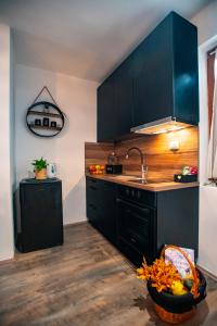 eine Küche mit schwarzen Schränken und einer Schale Obst in der Unterkunft Holiday home Tilia in Slatinski Drenovac