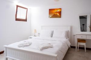 Un dormitorio con una cama blanca con toallas. en Lovely Villa with Backyard in Bozcaada near Beach, en Canakkale