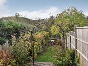 a garden with a gate in the middle of a yard at Vine Cottage in Crich