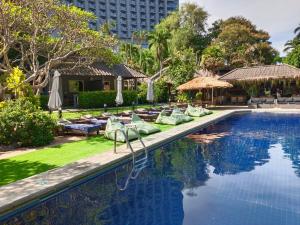 een zwembad met ligstoelen en een resort bij Let's Hyde Pattaya Resort & Villas - Pool Cabanas in Noord Pattaya