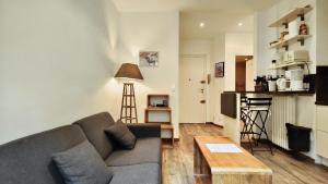 salon z kanapą i stołem w obiekcie Appartement maison Jeanne by Booking Guys w Nicei