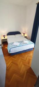 a bedroom with a bed and a wooden floor at Apartmani Kevric in Novi Vinodolski