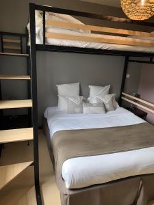 a bedroom with a bunk bed with white sheets and pillows at Le President-Gare Nimes Pont Du Gard in Bellegarde