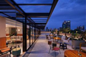a patio with tables and chairs and a view of the city at ARTOTEL Casa Kuningan in Jakarta