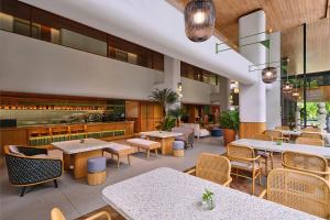 a restaurant with tables and chairs and a bar at ARTOTEL Casa Kuningan in Jakarta