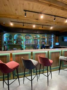 a bar with three chairs in front of a counter at Eco hotel & restaurant "SKALA" in Borovoye