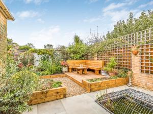 a garden with a wooden bench and a table at Pass the Keys Charming Annexe w Garden Parking Pass The Keys in Chichester