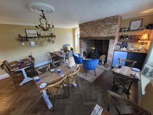 a living room with wooden tables and a fireplace at Belle Vue Guest House in Denver