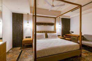 Avana- A Boutique Hotel في حيدر أباد: غرفة نوم مع سرير المظلة ومكتب