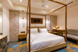 a bedroom with a canopy bed and a desk at Avana- A Boutique Hotel in Hyderabad