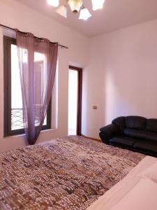 a bedroom with a bed and a couch and a window at Loft Garibaldi in Correggio