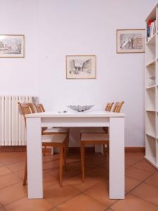 a white dining room table with chairs and a white wall at Loft Garibaldi in Correggio