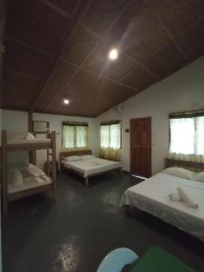 Zimmer mit 2 Betten und 2 Fenstern in der Unterkunft Tori's Backpacker's Paradise in Siquijor
