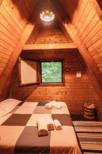 a bed in a wooden room with a window at Matilde's Chalet Etna Nature House in Nicolosi