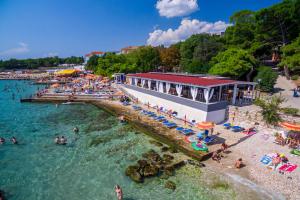 a group of people swimming in the water at a beach at Apartmani Kevric in Novi Vinodolski