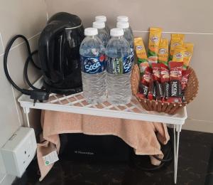 a shelf with two bottles of water and snacks at Labuan Paragon Apartment - 3 rooms in Labuan +4 photos