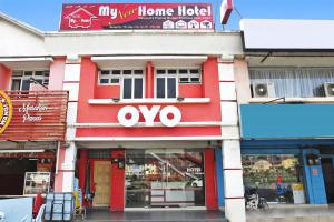 ein rot-weißes Gebäude mit einem Schild darauf in der Unterkunft OYO 89654 My New Home Hotel in Gua Musang