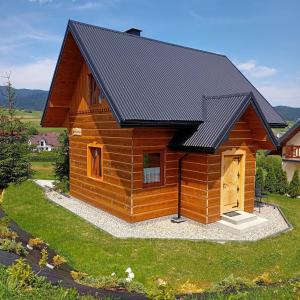 a log cabin with a black roof at Domek u Stolarza in Grywałd