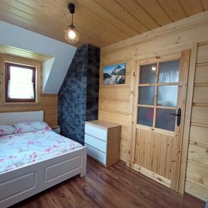 1 dormitorio con cama y ventana en Domek u Stolarza, en Grywałd