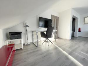 uma sala de estar com uma cadeira e uma secretária em F10 APARTMENT Illertissen SKY em Illertissen