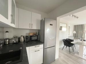 uma cozinha com um frigorífico de aço inoxidável e uma mesa em F10 APARTMENT Illertissen SKY em Illertissen