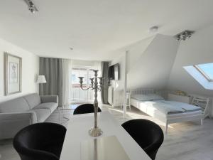 sala de estar blanca con sofá y cama en F10 APARTMENT Illertissen SKY, en Illertissen